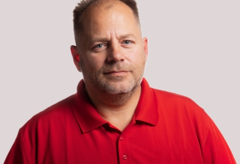 Porträt von Jens Gerlach im roten Poloshirt